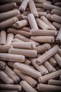 Collection of woodworking dowels on wooden board construction concept