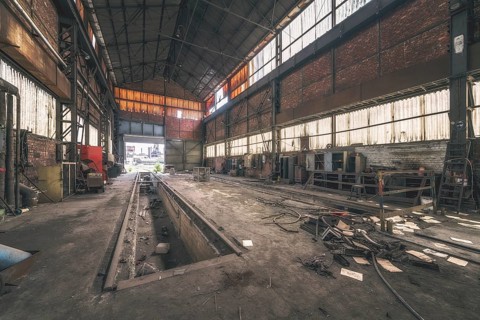 Dark, abandoned industrial hall with metal structures and rubbish on the floor, HF4 steelworks,