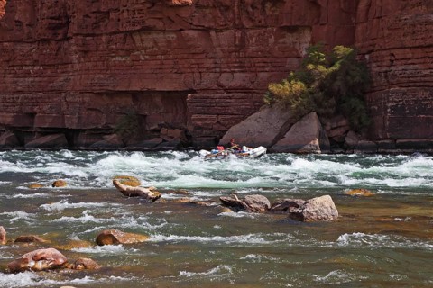 Sporting young woman in a kayak overcame stormy over the Colorado River