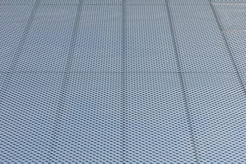 Closeup of metal mesh on concrete wall background texture