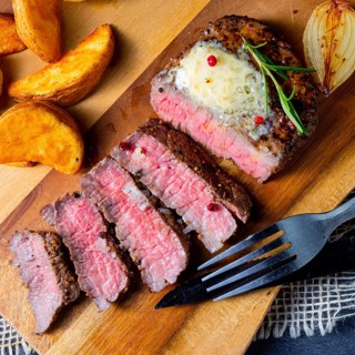 Rustic medium rare beef steak with herbs and potato wedges