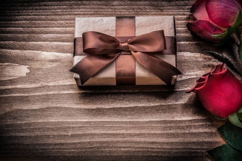 Red natural roses present box on wooden board holidays concept