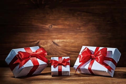 Giftboxes with red ribbons on vintage wood