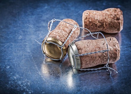 Alcohol cork plugs with twisted wires on metallic background