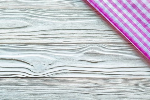 Pink checked towel on wooden board copy space