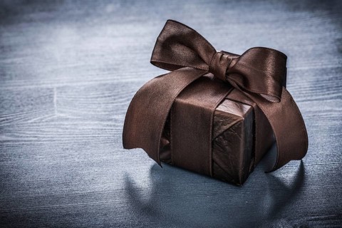 Giftbox shining paper on vintage wooden board holiday concept