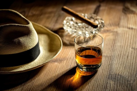 A glass of rum, a cigar and a Panama hat in a bar in Cuba