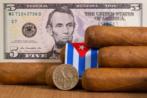Luxury Cuban cigars with US dollar banknote and coin on the wooden table