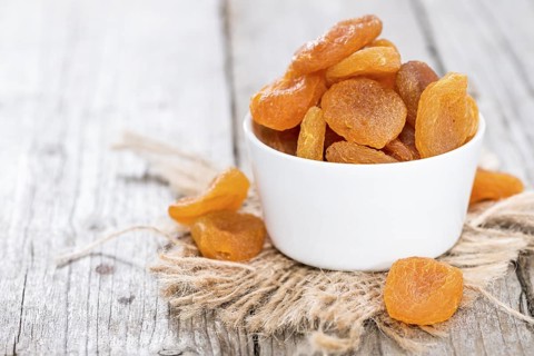 Small portion of dried Apricots (on wooden background)