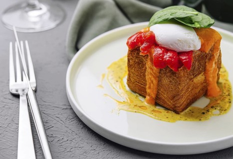 Food, Elegant brunch dish featuring a poached egg on top of french toast with a red pepper sauce