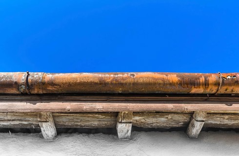 A broken gutter on the roof of a house