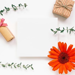 Empty memo paper with flower and gift on white background. flat lay, top view, copy space