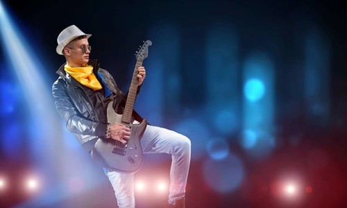 Young man rock musician in lights of stage