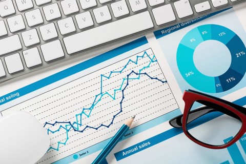Business workplace with keyboard mouse and papers with graphs and diagrams