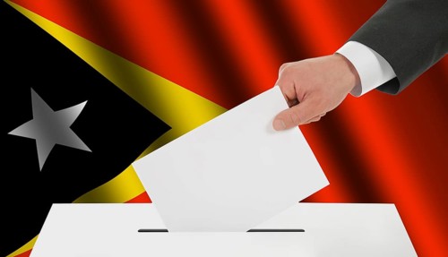 The East Timor flag and the hand with the bulletin about the ballot box