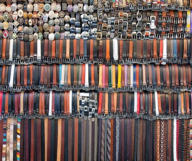 Many colored leather belts on a market