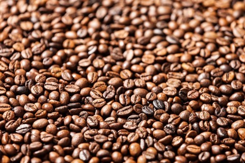 Brown roasted raw coffee bean heap background