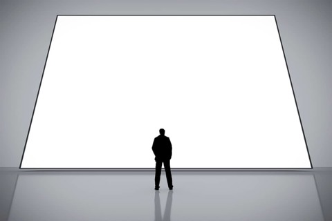 A man in front of a big white empty screen