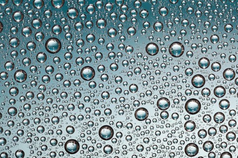 Crystal clear water drops over blue background