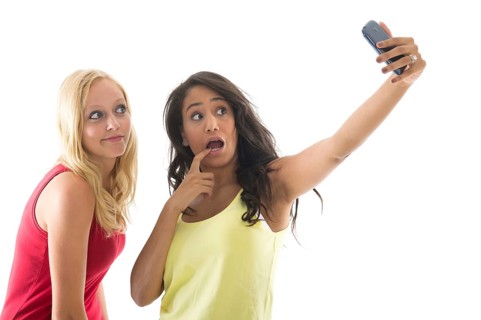 Girlfriends taking selfie with cell phone