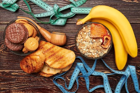 Measuring tapes, fruits and sweets. Struggle to get healthy