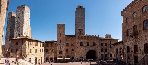 Main square Piazza del Duomo in San Gimignano with its famous palace towers, Italy