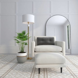 A cozy modern room with an armchair, floor lamp, potted plant, and mirror