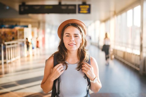 Theme tourism travel. Young beautiful Caucasian woman in dress and hat with backpack tourist mat in
