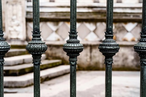 Antique wrought iron fence with decorative spherical inserts.