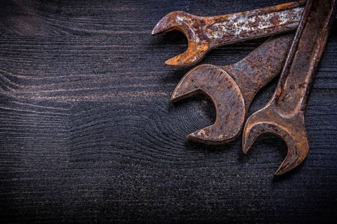 Vintage grunge open-end wrenches on wood board construction concept