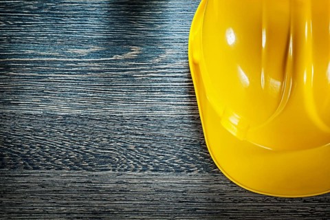 Safety building helmet on wooden board