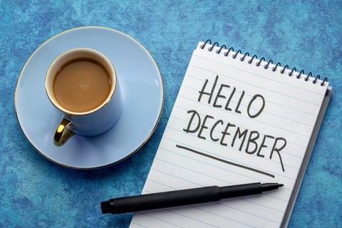 Hello December - handwriting in a notebook with a cup of coffee