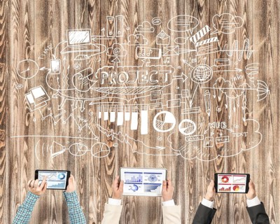 Group of three people with devices in hands working together as symbol of networking and