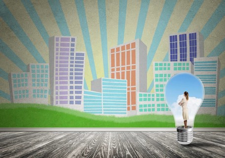 Businesswoman inside light bulb against city drawn concept