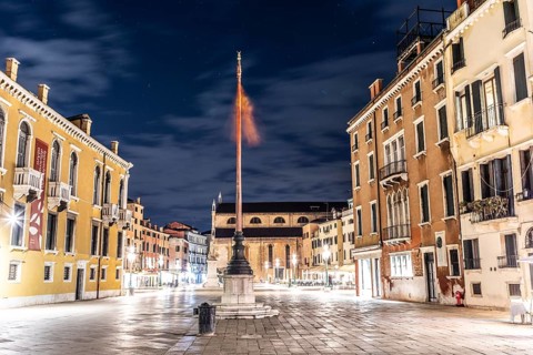 Venetian flag waving in the wind, illuminated facades, Campo Santo Stefano, night shot, Venice,