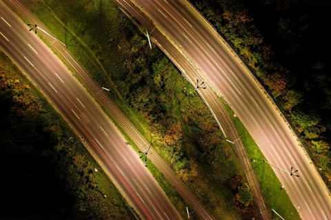 Top down view to road. Romantic night aerial photo of cars traveling. The light on the road at