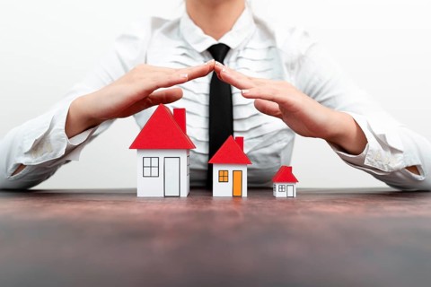 Protecting Hands Over House, Home Security And Protection Concept. hands holding paper, family