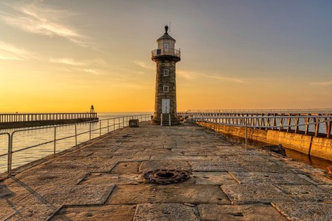 Golden Hour at the East Pier and Whitby East Harbour Lighthouse in Whitby, North Yorkshire,