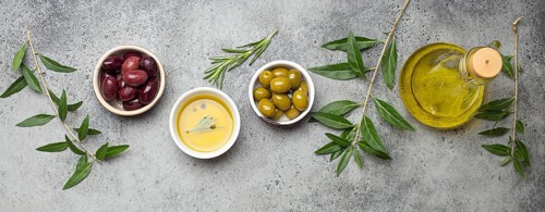 Composition with green and brown olives, extra virgin olive oil in glass bottle, olive tree