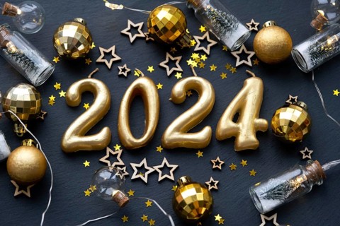 The golden figures 2024 made of candles on a black stone slate background are decorated with a