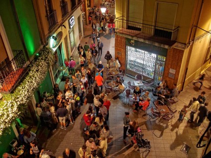 People of all ages enjoy a a party on the Torres de Omana Square on a mild autumn evening, Leon,
