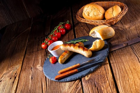 Rustic bratwurst with ketchup and fresh rolls