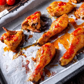 Rustic backed chicken wings, legs on baking tray