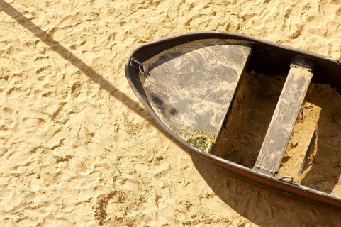 Aerial view and top view of a sandy beach with an old tin rowing boat
