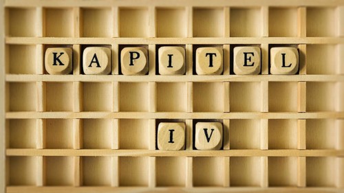 An image of a wooden game with the word chapter four in german language
