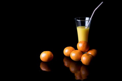 Orange juice and mandarins on black