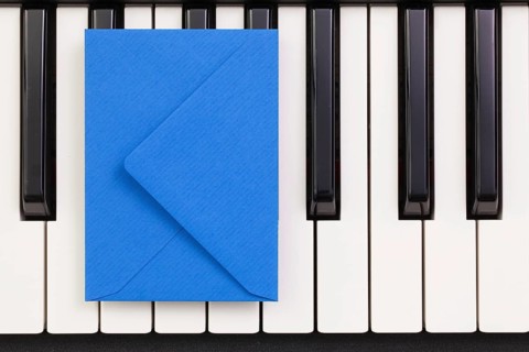 Funny arrangement envelope on the piano keybords - Flat lay image