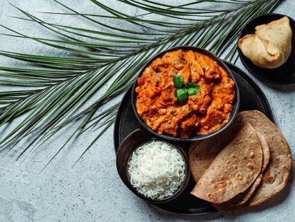 Indian cuisine dishes: tikka masala, rice, samosa, chapati, . Indian food on gray stone background