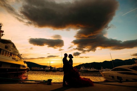 Couple hugging each other at sunset on a boat pier.