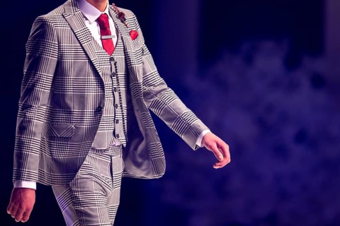 Male model walks the runway in grey suit during a Fashion Show. Fashion catwalk event showing new